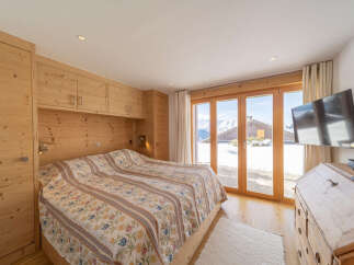 Experience the charm of this cozy bedroom featuring natural wood accents and a stunning view.