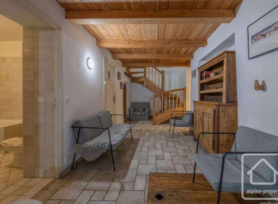 Discover the charm of this inviting property, featuring a warm wooden ceiling and a cozy seating area.