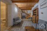 Discover the charm of this inviting property, featuring a warm wooden ceiling and a cozy seating area.
