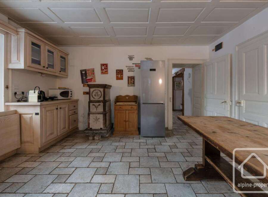 This charming kitchen boasts a rustic design with wooden cabinetry and a stone tile floor.