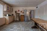 This charming kitchen boasts a rustic design with wooden cabinetry and a stone tile floor.