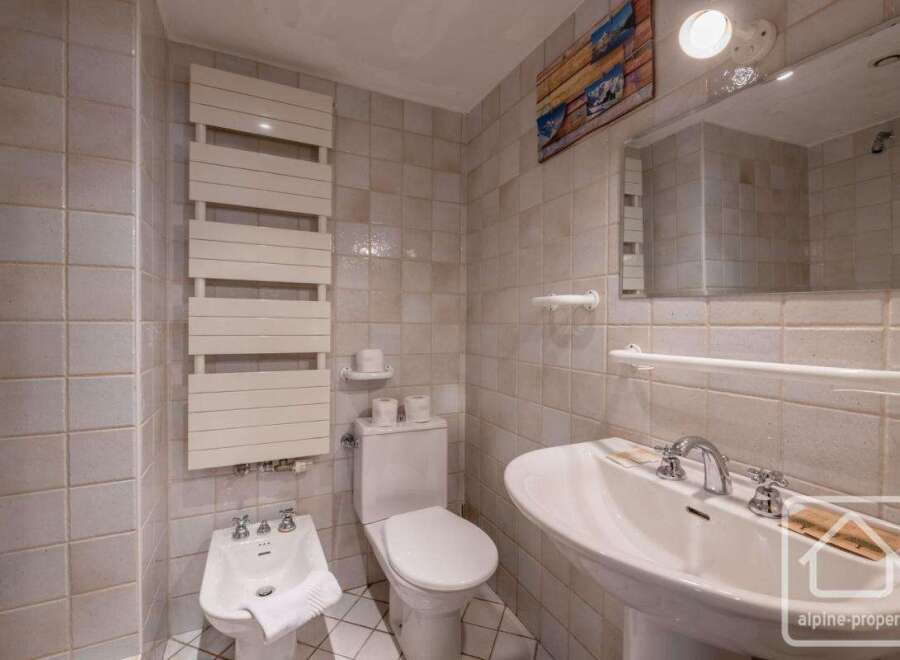 This bathroom features a modern design with a sleek white sink and a stylish towel rack.