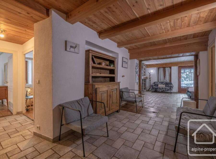 Discover the charm of this inviting property, featuring a warm wooden ceiling and a cozy living area.
