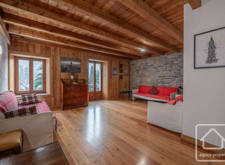 This stunning property boasts a warm and inviting interior with exposed wooden beams and flooring.
