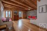 This stunning property boasts a warm and inviting interior with exposed wooden beams and flooring.