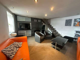 This modern living space features a vibrant orange sofa complemented by zebra-print pillows, creating a stylish focal point.