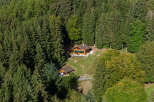Nestled in a lush, green forest, this charming wooden cabin offers a serene escape.