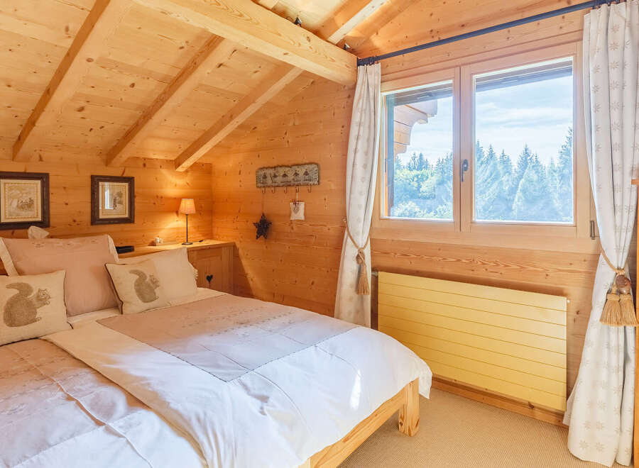 This cozy bedroom features a warm, inviting ambiance with its wooden walls and ceiling.