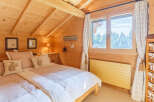 This cozy bedroom features a warm, inviting ambiance with its wooden walls and ceiling.