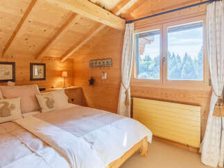 This cozy bedroom features a warm, inviting ambiance with its wooden walls and ceiling.