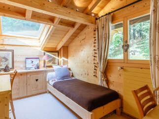 This charming bedroom features a cozy, wooden interior, creating a warm and inviting atmosphere.