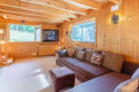Step into this cozy cabin retreat, featuring warm wood paneling and a comfortable living space.
