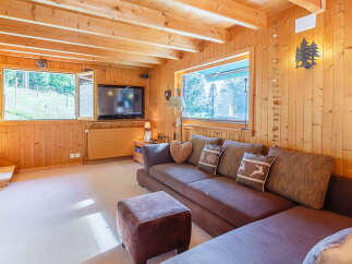 Step into this cozy cabin retreat, featuring warm wood paneling and a comfortable living space.