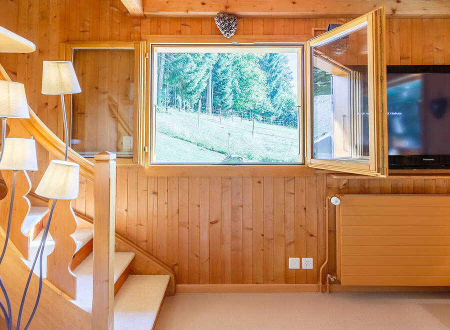 This charming property features a cozy interior with warm wooden paneling and a welcoming atmosphere.