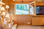 This charming property features a cozy interior with warm wooden paneling and a welcoming atmosphere.