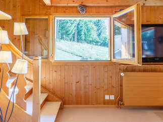 This charming property features a cozy interior with warm wooden paneling and a welcoming atmosphere.