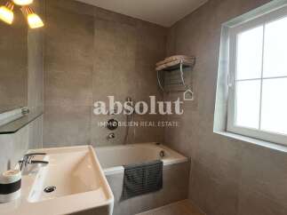 Discover a modern bathroom design featuring a sleek bathtub, a stylish sink, and elegant tile work.