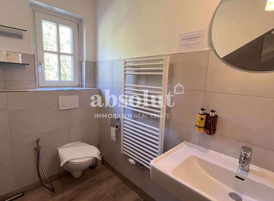 Discover this modern bathroom featuring a sleek design and essential amenities.