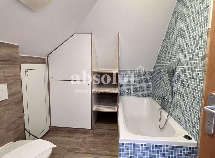 Discover this charming bathroom featuring a stylish bathtub and mosaic tile accents.