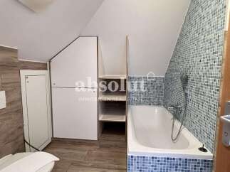 Discover this charming bathroom featuring a stylish bathtub and mosaic tile accents.