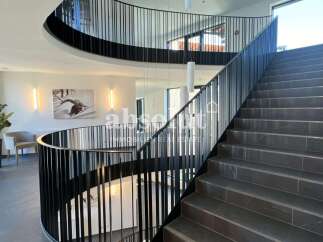 Discover the epitome of modern elegance in this stunning property, featuring a grand staircase that leads to multiple levels.