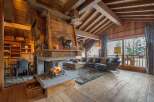 Experience the warmth of this stunning chalet, featuring a grand fireplace and exposed wooden beams that create a cozy atmosphere.