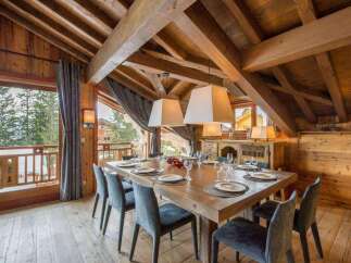 Experience luxury living in this stunning property featuring a spacious dining area with a large wooden table, perfect for hosting gatherings.