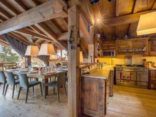 Experience rustic elegance in this stunning property, featuring a beautifully designed dining area with a large wooden table and stylish chairs.