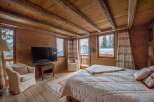 Experience the charm of this cozy mountain retreat! This bedroom features a rustic wooden interior, creating a warm and inviting atmosphere.