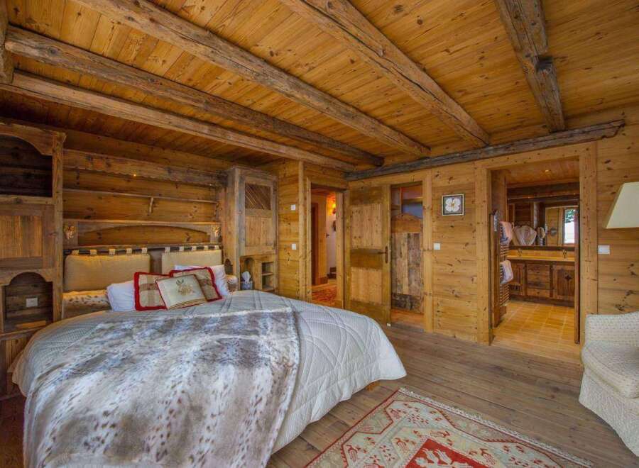 Step into rustic luxury with this stunning bedroom, featuring warm wooden accents and a cozy ambiance.