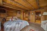 Step into rustic luxury with this stunning bedroom, featuring warm wooden accents and a cozy ambiance.