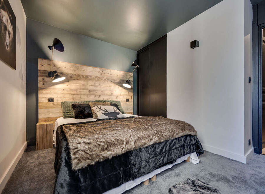 This cozy bedroom features a rustic wooden headboard, creating a warm and inviting atmosphere.