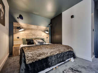 This cozy bedroom features a rustic wooden headboard, creating a warm and inviting atmosphere.