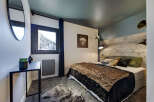 Experience the cozy charm of this bedroom, featuring a rustic wooden headboard and a plush, inviting bedspread.