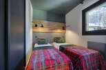 Cozy bedroom featuring two twin beds with vibrant plaid bedding, perfect for a comfortable stay.