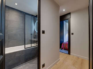 Step into modern elegance with this stunning property, featuring a beautifully designed bathroom with sleek gray tiles and a glass shower enclosure.