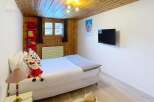 This cozy bedroom features a warm wooden ceiling and walls, creating a rustic and inviting atmosphere.