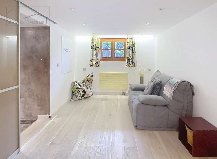 Discover this charming property featuring a cozy living space with a comfortable sofa and a unique patterned beanbag chair.