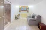 Discover this charming property featuring a cozy living space with a comfortable sofa and a unique patterned beanbag chair.