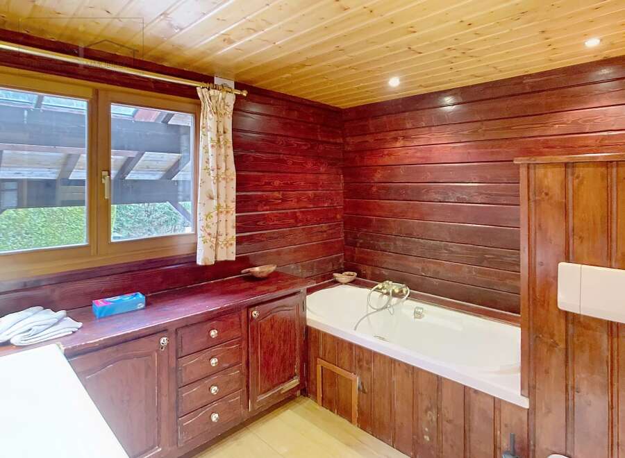 This charming bathroom features warm wood paneling and a cozy atmosphere.