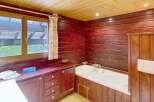 This charming bathroom features warm wood paneling and a cozy atmosphere.
