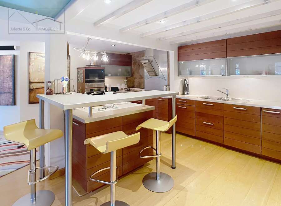 This stunning kitchen boasts modern design with sleek cabinetry and a breakfast bar, perfect for entertaining.