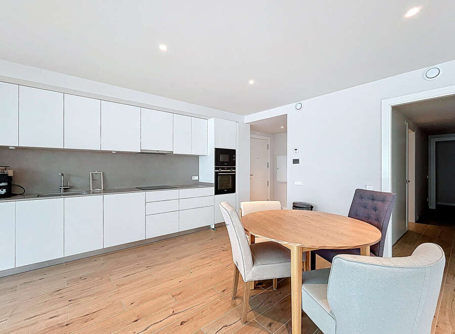 This modern kitchen and dining area offers a sleek and stylish design, perfect for contemporary living.