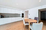 This modern kitchen and dining area offers a sleek and stylish design, perfect for contemporary living.