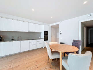 This modern kitchen and dining area offers a sleek and stylish design, perfect for contemporary living.