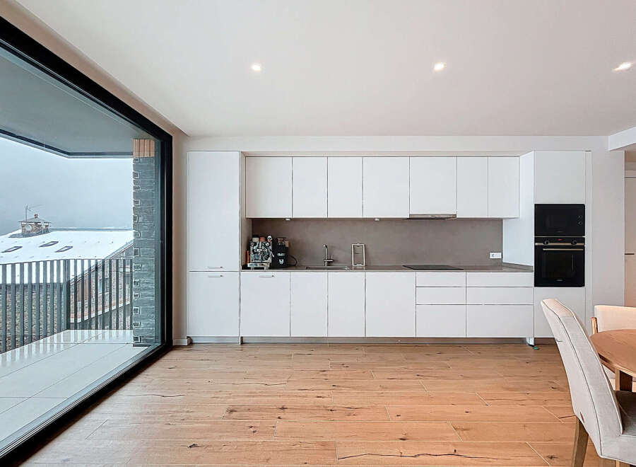 Experience modern living in this stunning kitchen, featuring sleek white cabinetry and a contemporary design.