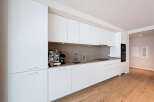 This modern kitchen boasts sleek, white cabinetry and a minimalist design, perfect for contemporary living.