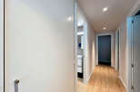 Step into this beautifully designed hallway, showcasing a modern aesthetic with its sleek white doors and warm wooden flooring.