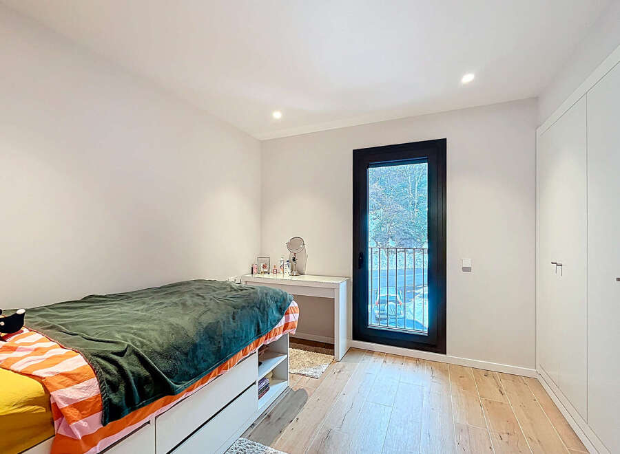 This bright and airy bedroom offers a serene retreat with its neutral color palette and ample natural light.