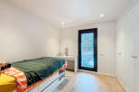 This bright and airy bedroom offers a serene retreat with its neutral color palette and ample natural light.